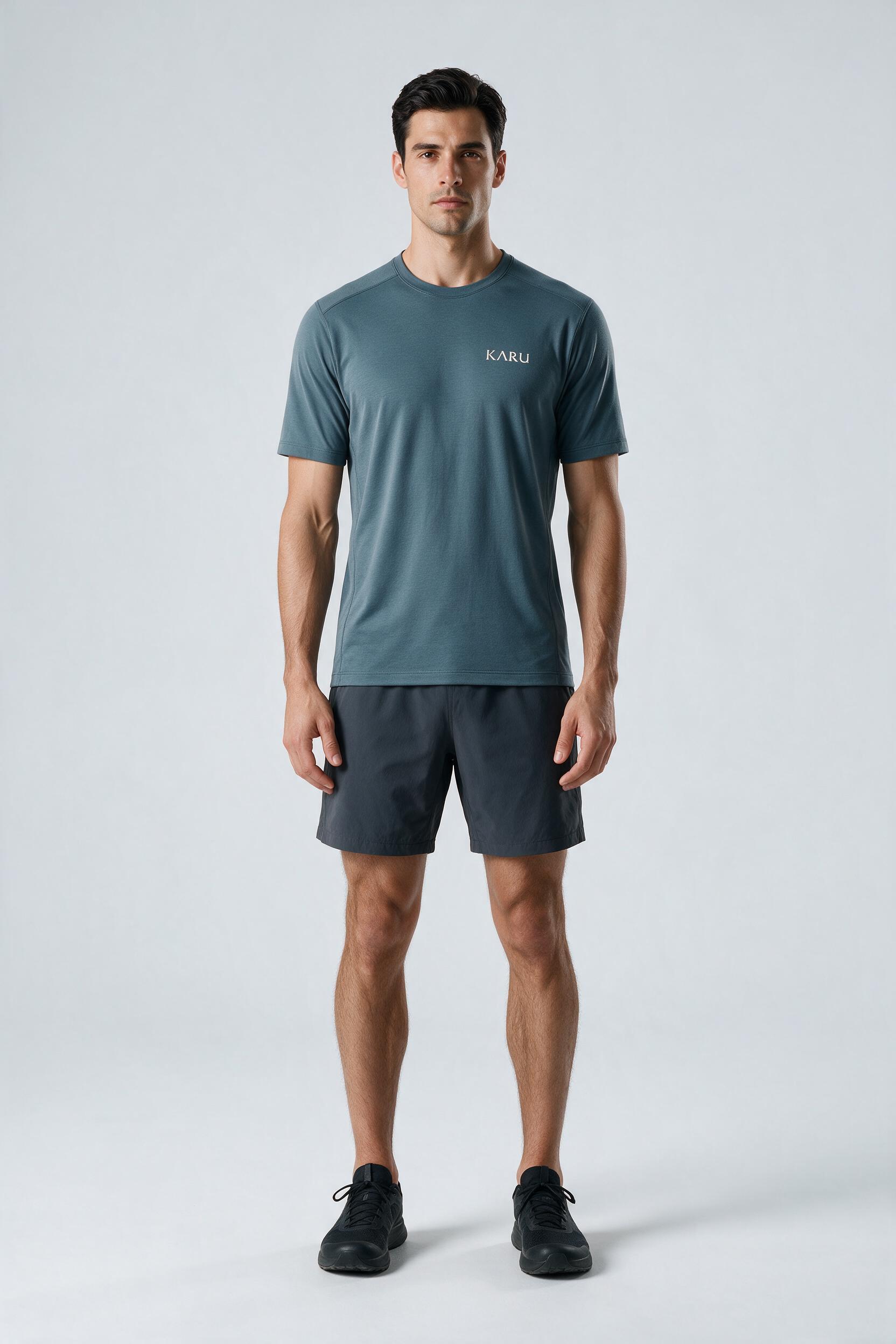 Hetta Tee in slate blue-grey, worn by a model, studio product shot on a seamless neutral ground