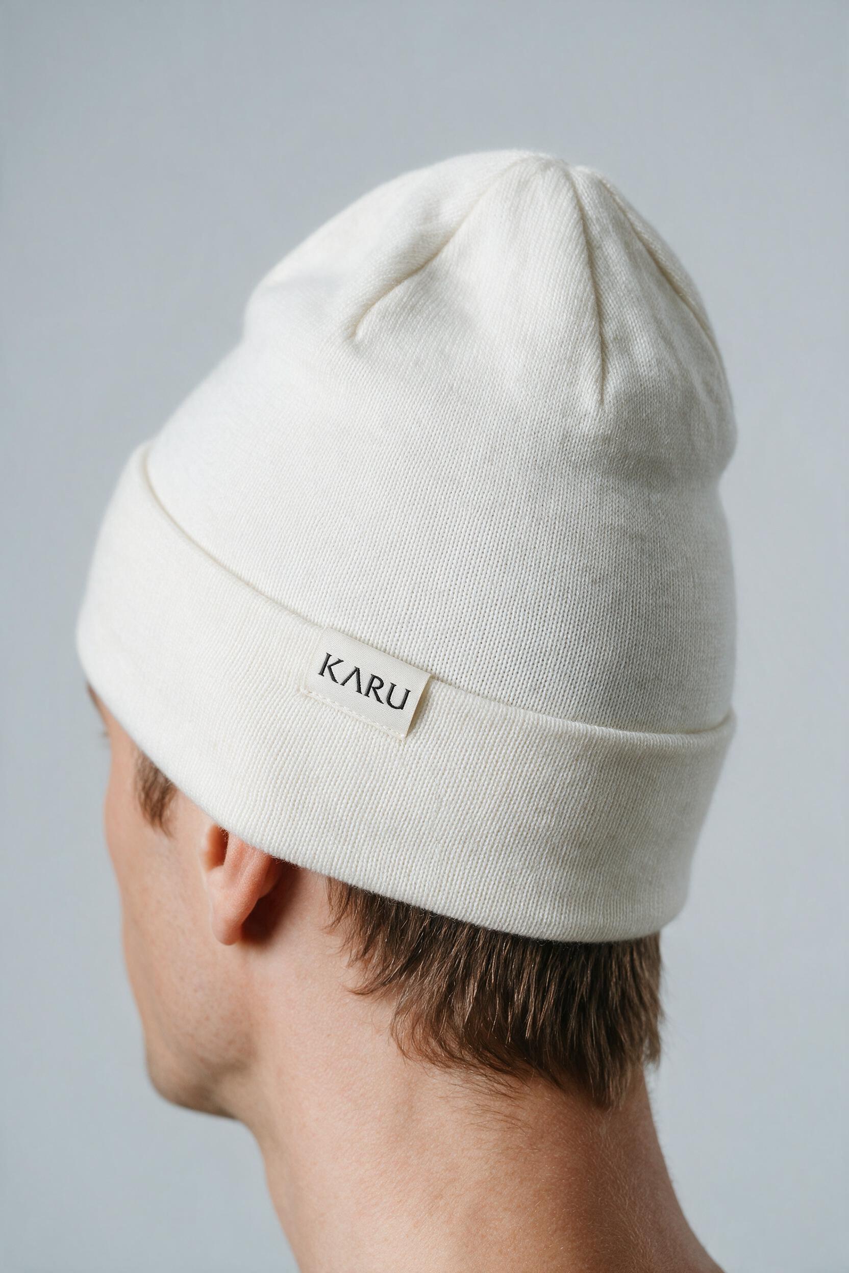 Låkta Beanie in bone, worn by a model, studio product shot on a seamless neutral ground