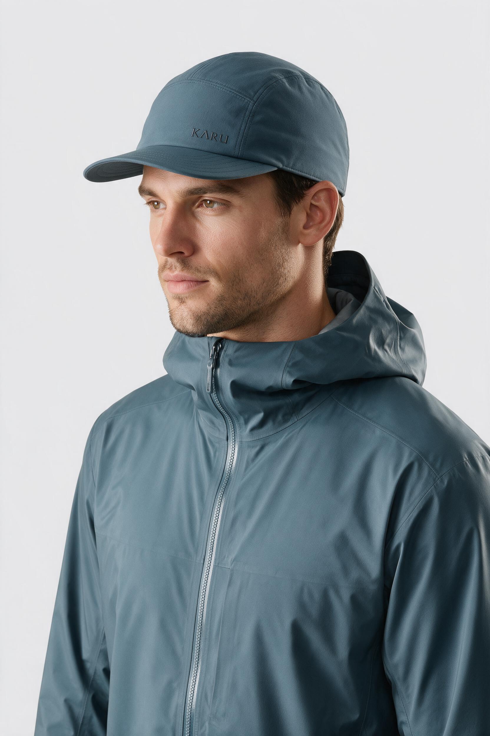 Ounas Cap in slate blue-grey, worn by a model, studio product shot on a seamless neutral ground