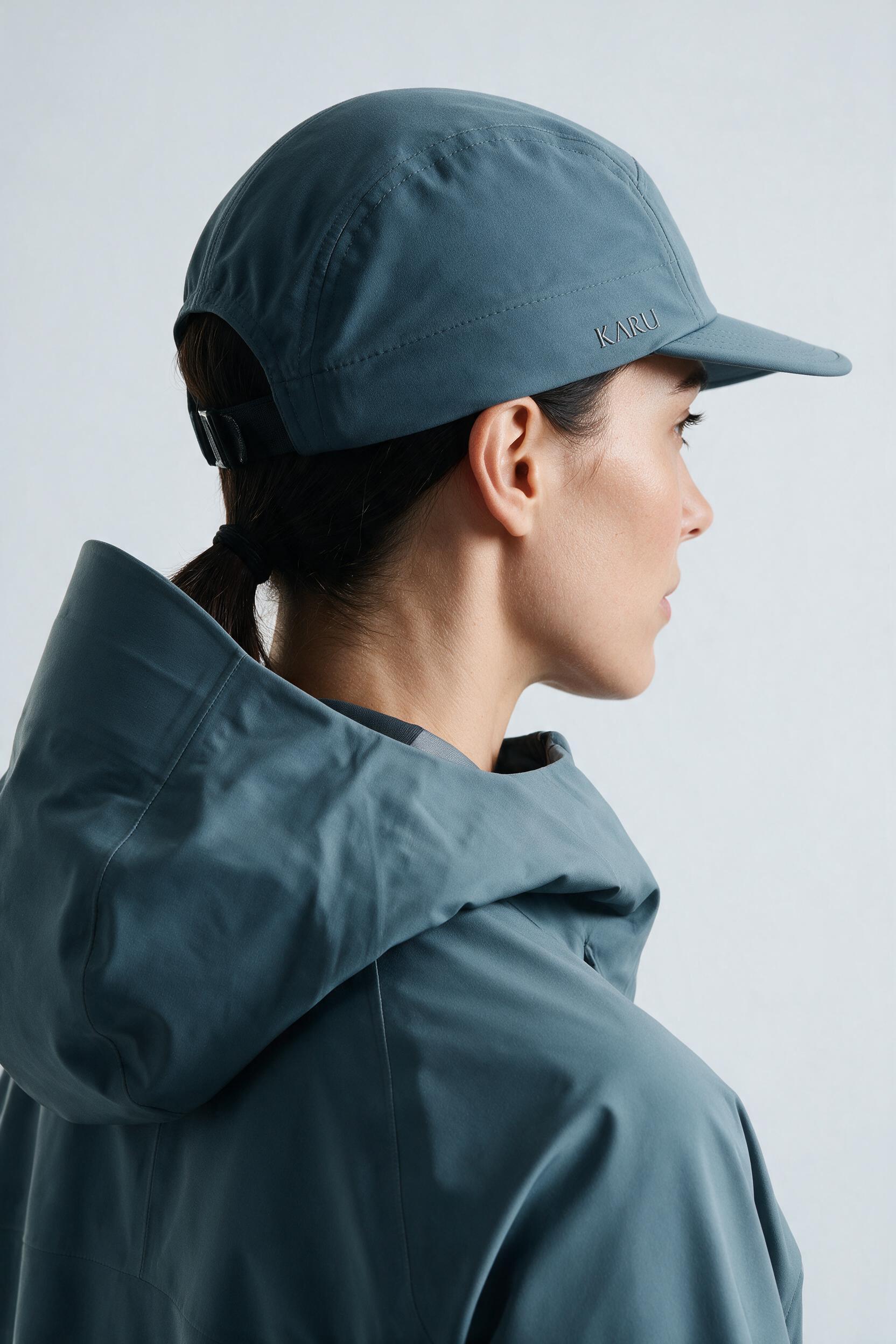 Ounas Cap in slate blue-grey, worn by a model, studio product shot on a seamless neutral ground