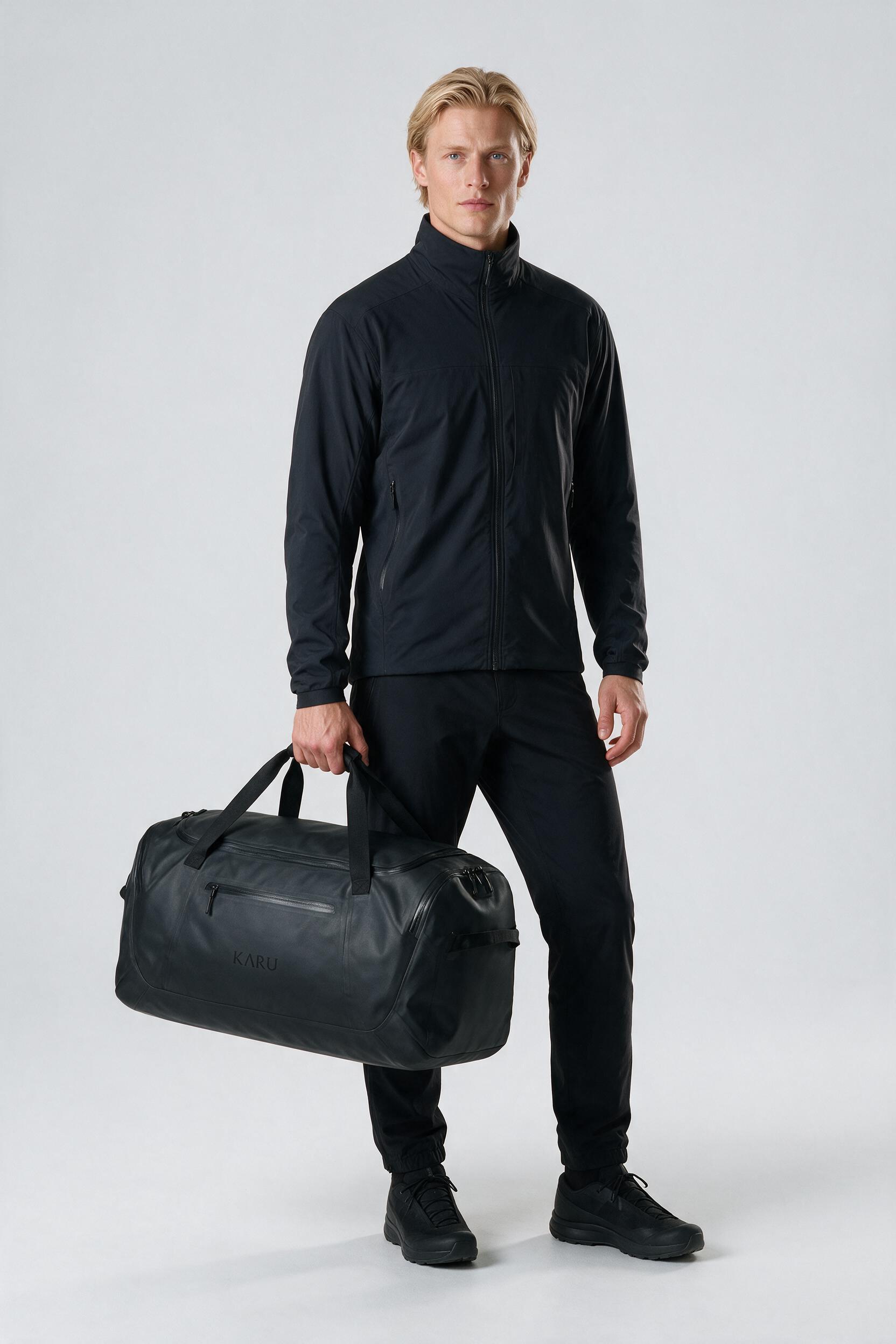 Ritsem Duffel 60 pack in night black, worn on the back, studio product shot on a seamless neutral ground