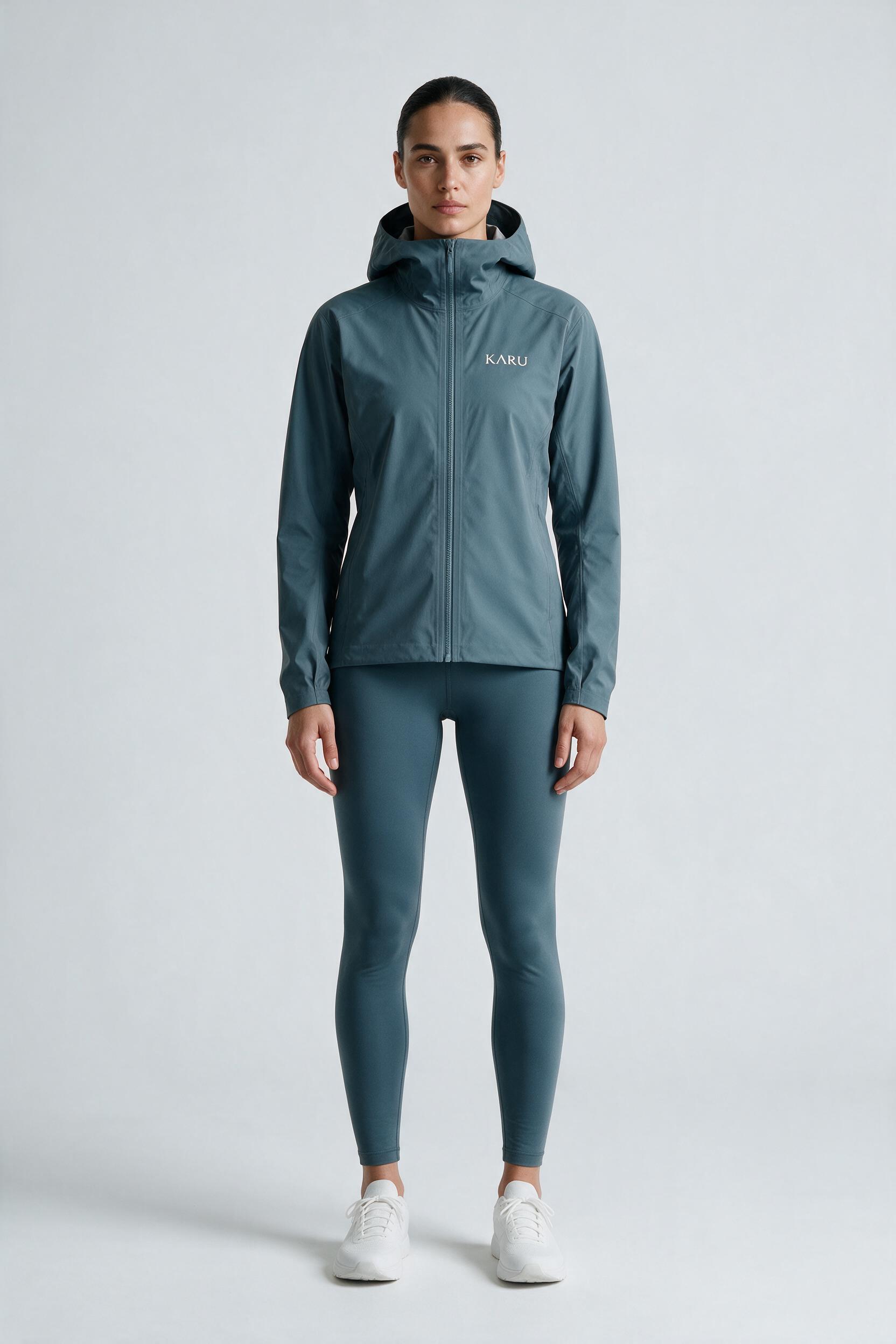 Singi Shell in slate blue-grey, worn by a model, studio product shot on a seamless neutral ground