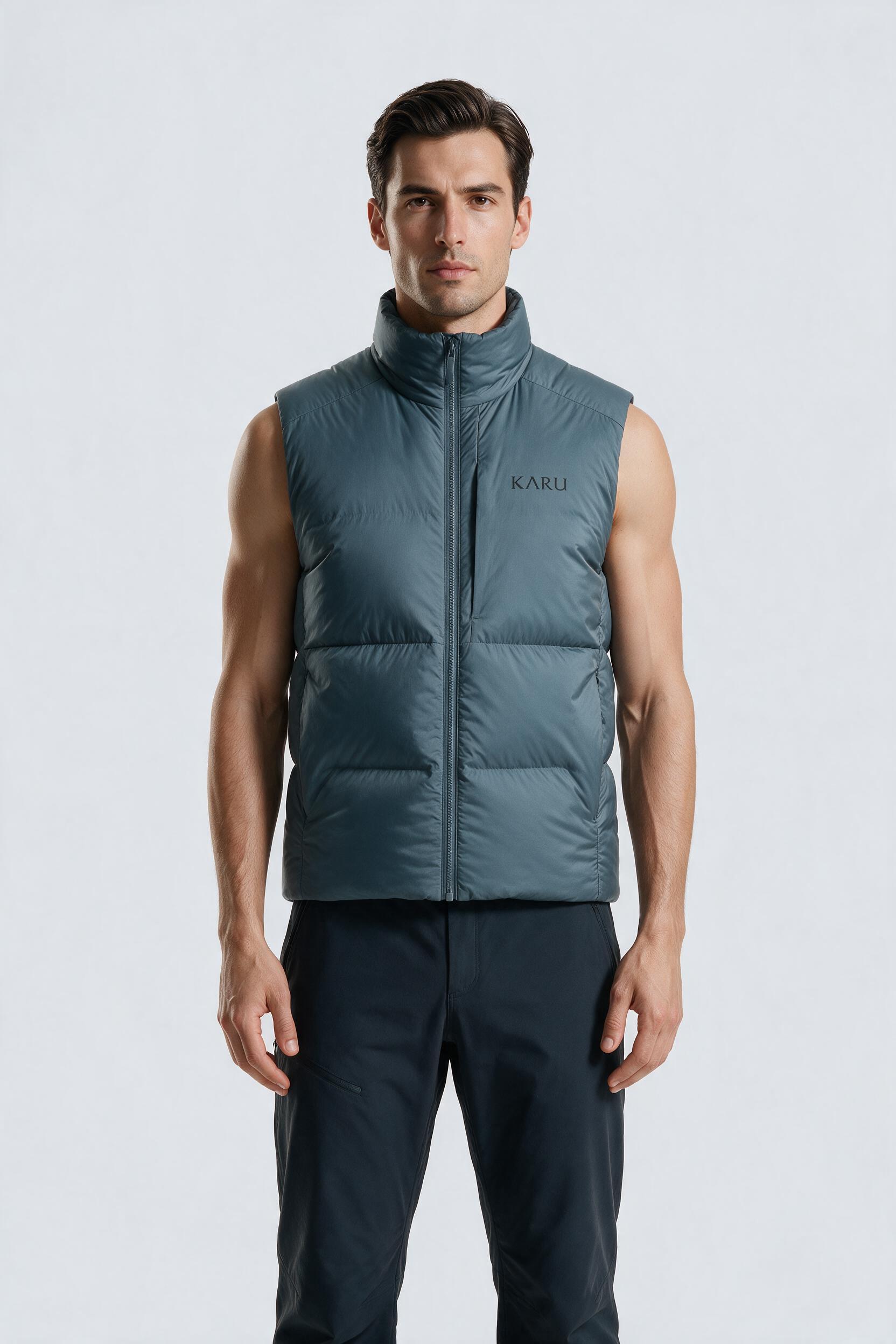 Sitas Vest in slate blue-grey, worn by a model, studio product shot on a seamless neutral ground